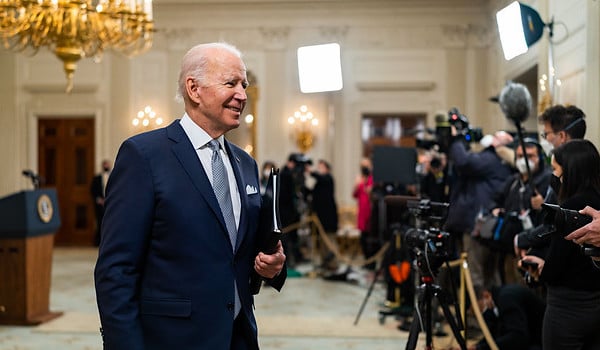 Joe Biden smiles as he walks past members of the press after his remarks on the December jobs report, Friday, Jan. 7, 2022, in the State Dining Room of the White House. (Official White House photo by Cameron Smith)