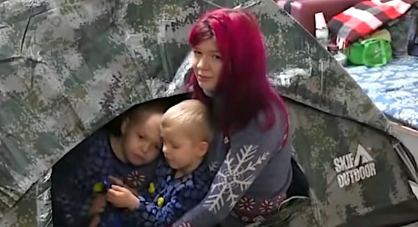 A Ukrainian mother comforts her sone inside a tent amid Russia's invasion of her country. (Video screenshot)