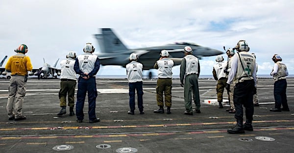 Military leaders from Colombia and Israel observe an F/A-18F Super Hornet assigned to the "Black Aces" of Strike Fighter Squadron 41 make an arrested landing on the flight deck of the Nimitz-class aircraft carrier USS Abraham Lincoln during Rim of the Pacific (RIMPAC) on July 20, 2022. (U.S. Navy photo by Mass Communication Specialist 3rd Class Michael Singley)